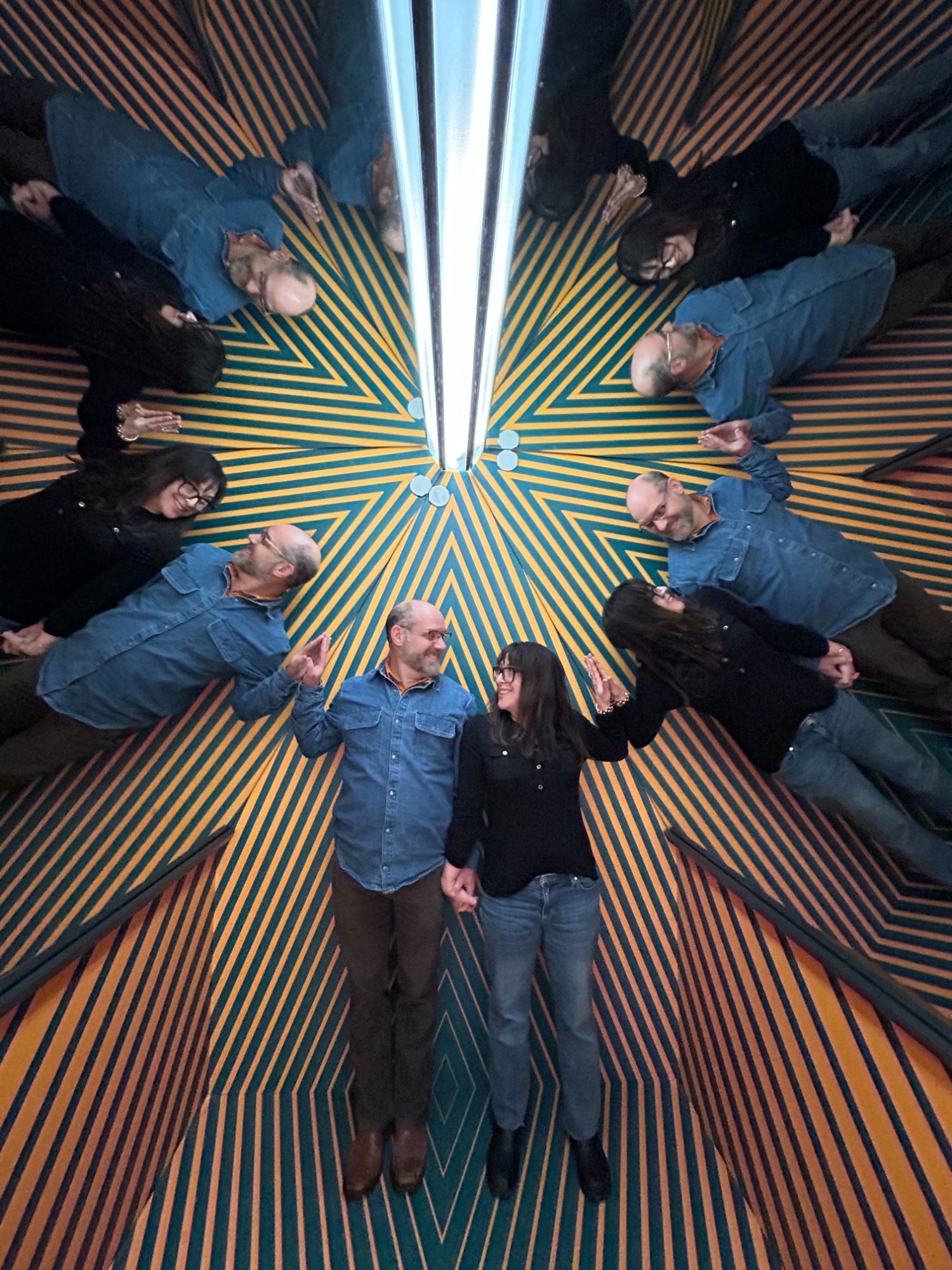 Jay Strear and his wife Beth standing in a mirrored kaleidoscope room