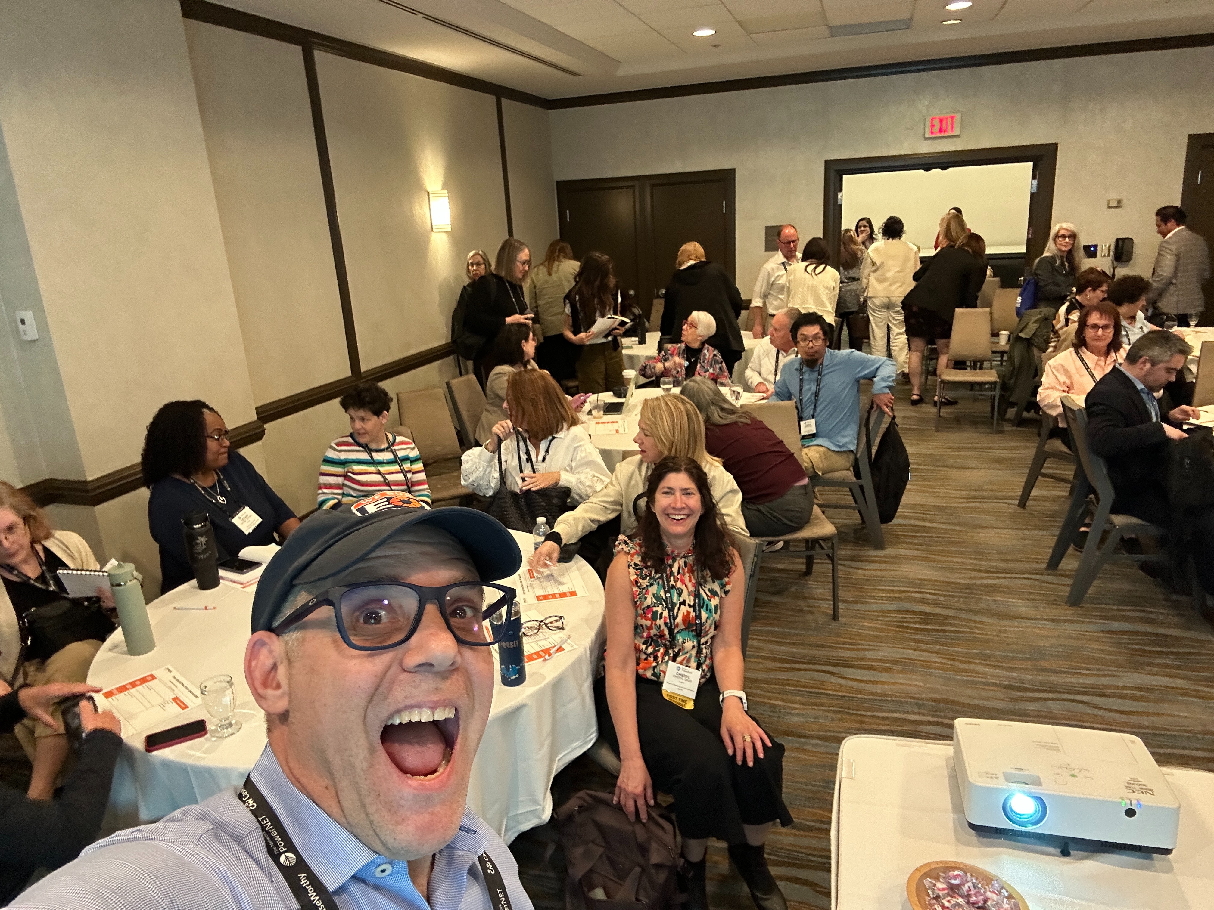 Jay Strear in a hotel conference room filled with nonprofit leaders seated at round tables during a working session